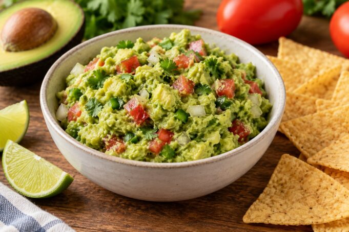 Homemade guacamole with lime and cilantro Homemade guacamole with chunky avocado, tomato and cilantro, served with lime and tortilla chips.